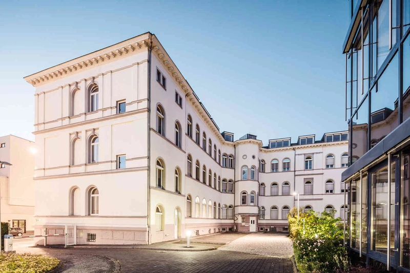 Moderne Au&szlig;enansicht der Oberberg Tagesklinik Frankfurt am Main &ndash; helles Geb&auml;ude mit gro&szlig;em Eingangsbereich, Glasfront im Vordergrund