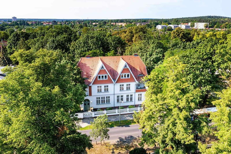 Vogelperspektive auf das Geb&auml;ude der Oberberg Tagesklinik Potsdam in der Geschwister-Scholl-Stra&szlig;e, umgeben von B&auml;umen und Gr&uuml;n vom Park Sanssouci
