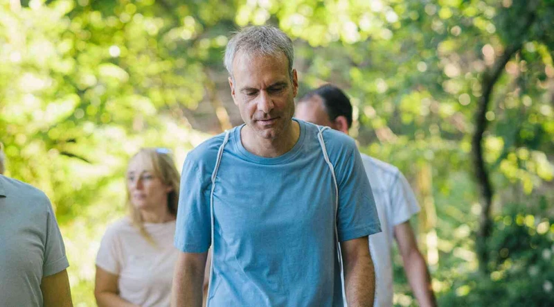 Mann spaziert drau&szlig;en im wald mit einer gruppe