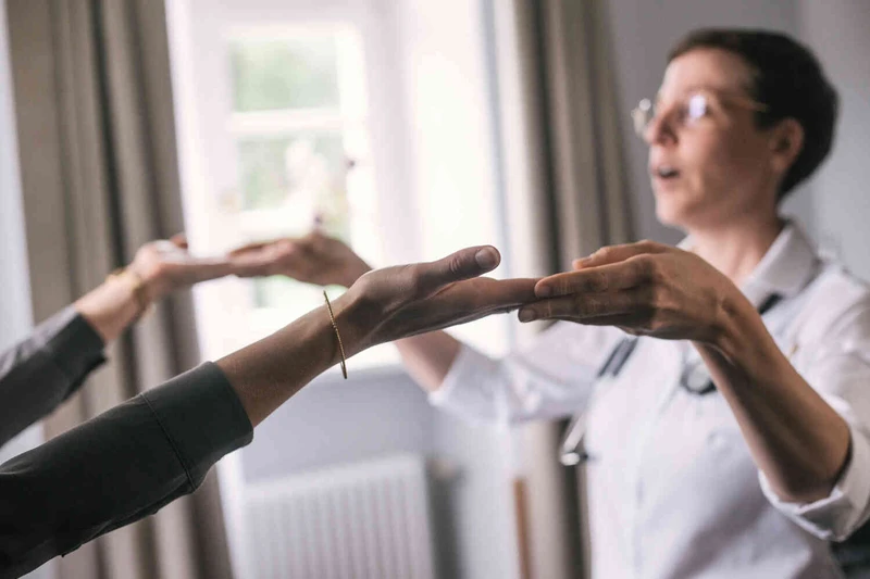 &Auml;rztin h&auml;lt H&auml;nde der Patientin und f&uuml;hrt sie durch thepraie